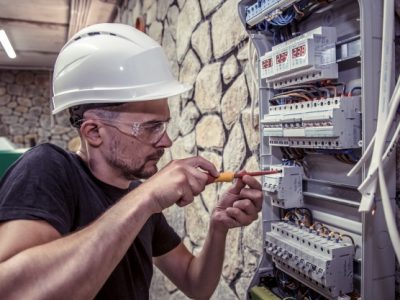 male-electrician-works-switchboard-with-electrical-connecting-cable_169016-1473