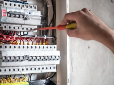 man-electrical-technician-working-switchboard-with-fuses-installation-connection-electrical-equipment-close-up_169016-5077
